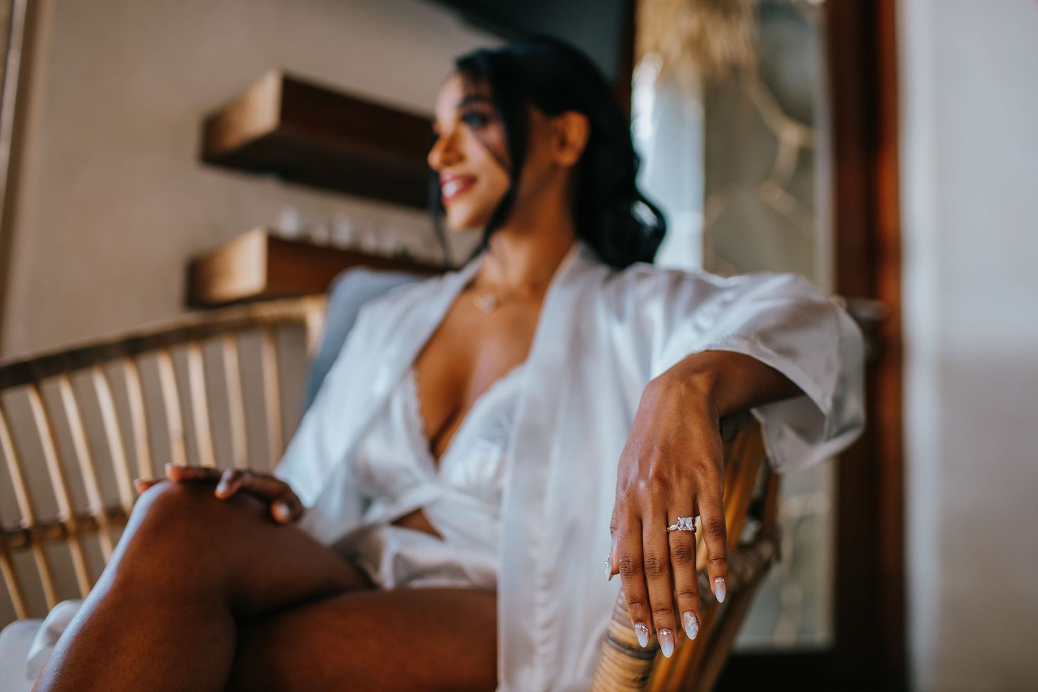 A person wearing a white button-up shirt laughs while sitting in a chair during a candid moment.