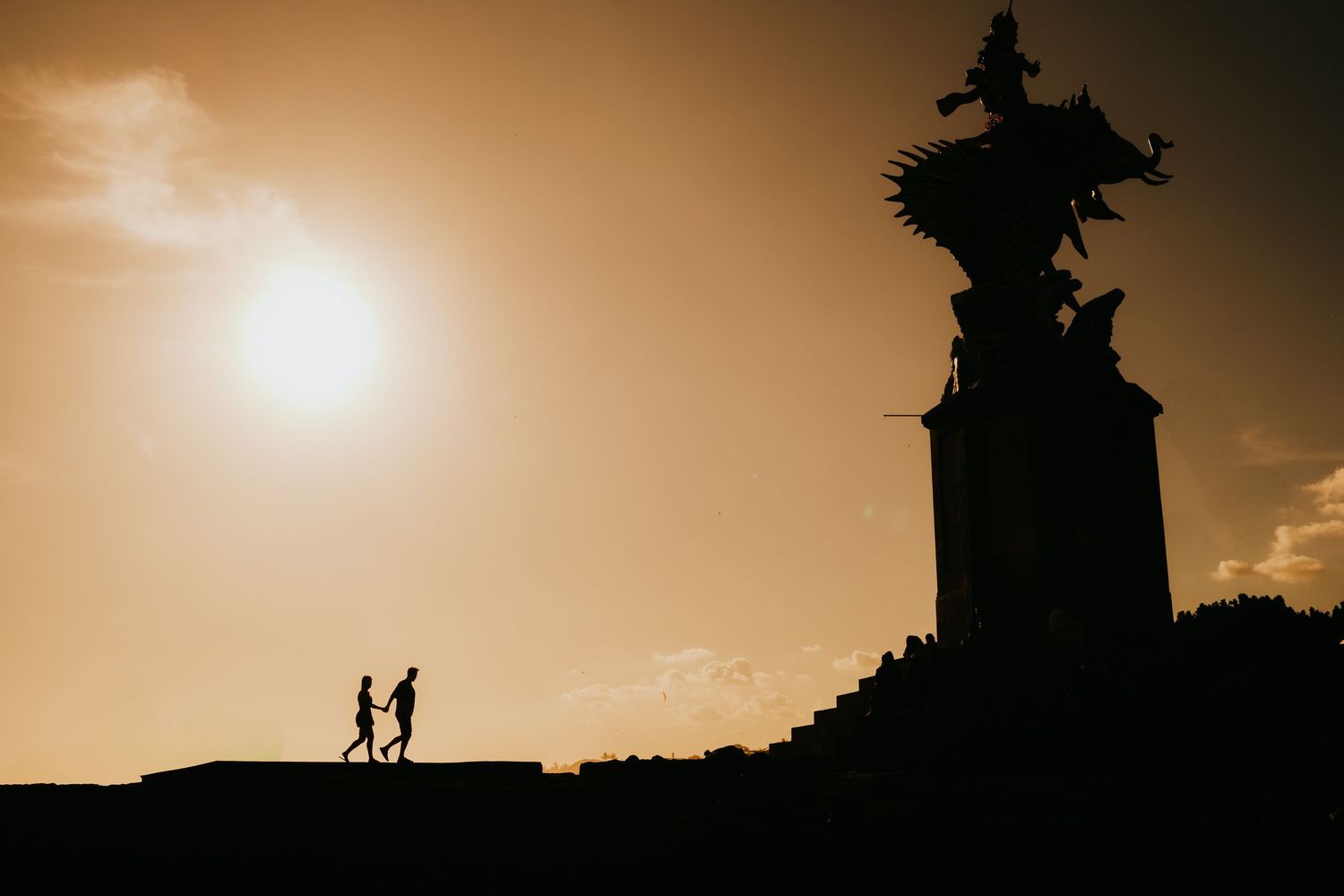 Golden sunset silhouettes creating romantic atmosphere against warm sky.