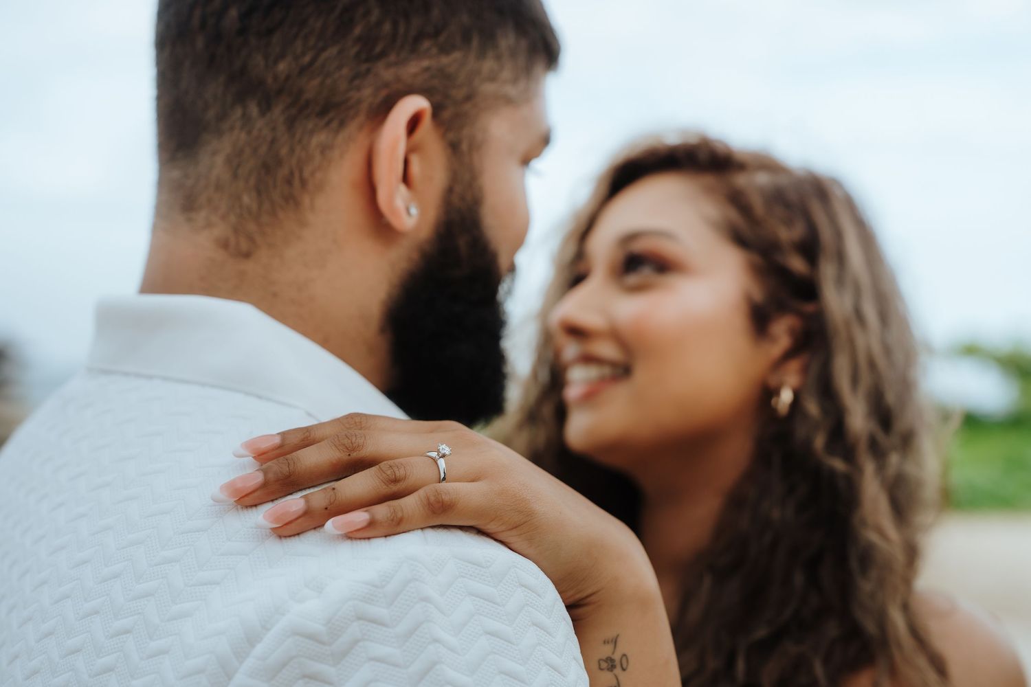 A romantic couple embraces intimately during a sunset photoshoot on the beach.