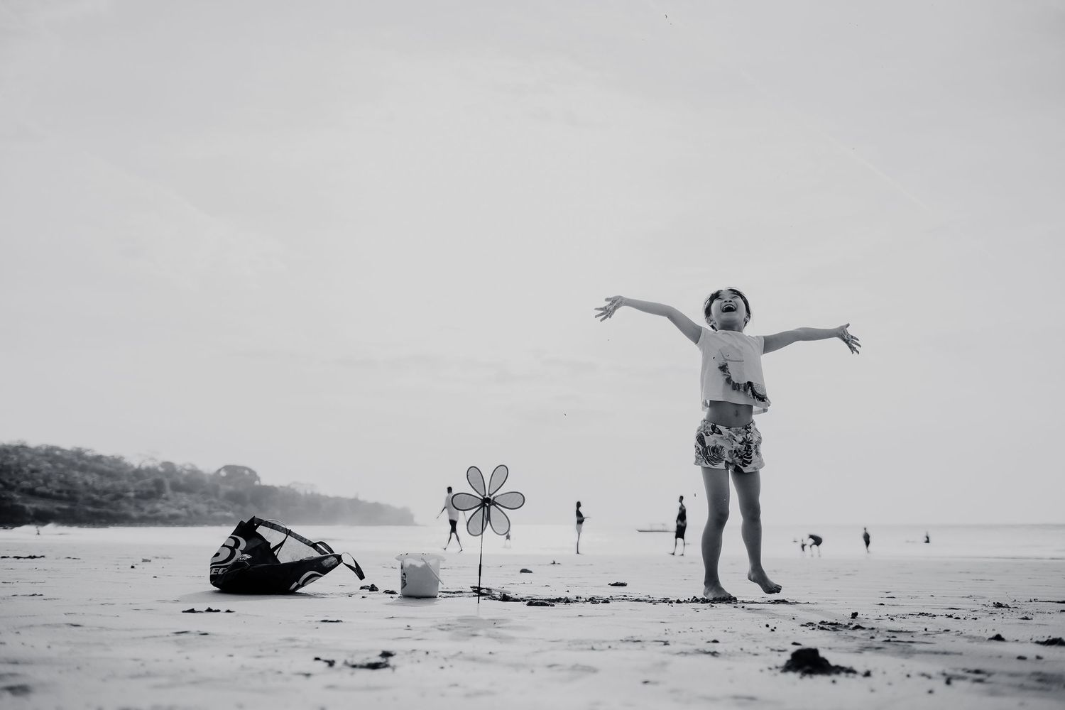 Black and white photos of joyful moments and jumping silhouettes on a misty beach.