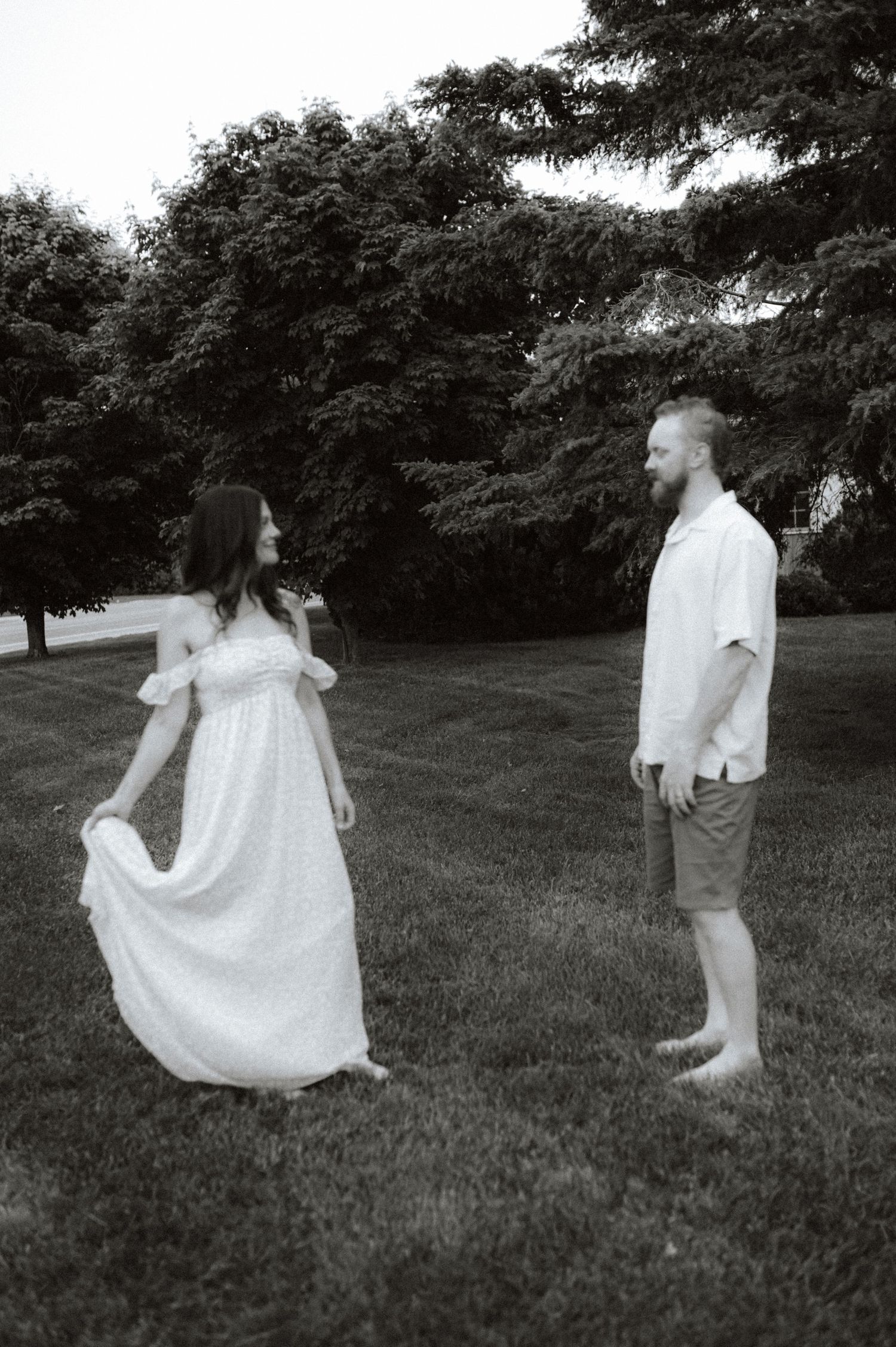 A series of black and white photos showing people jumping carefree in a grassy field with trees in the background.