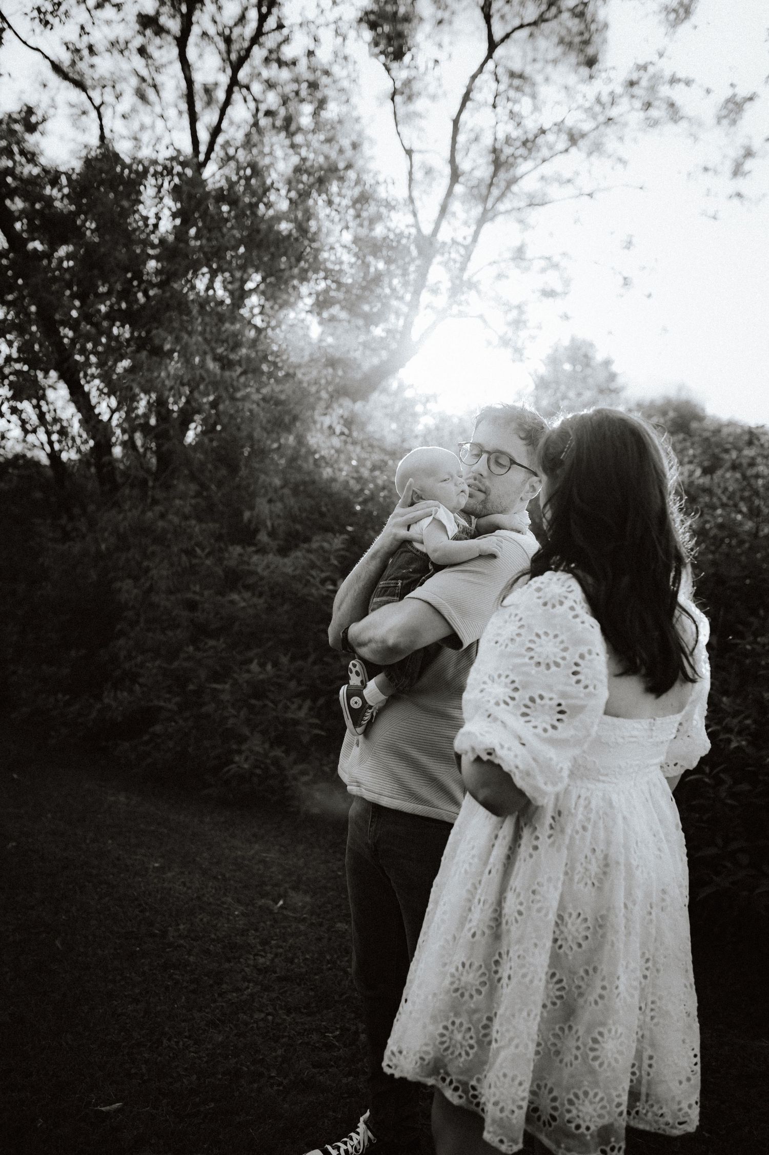 A romantic black and white photo sequence showing a couple embracing tenderly in a wooded outdoor setting.