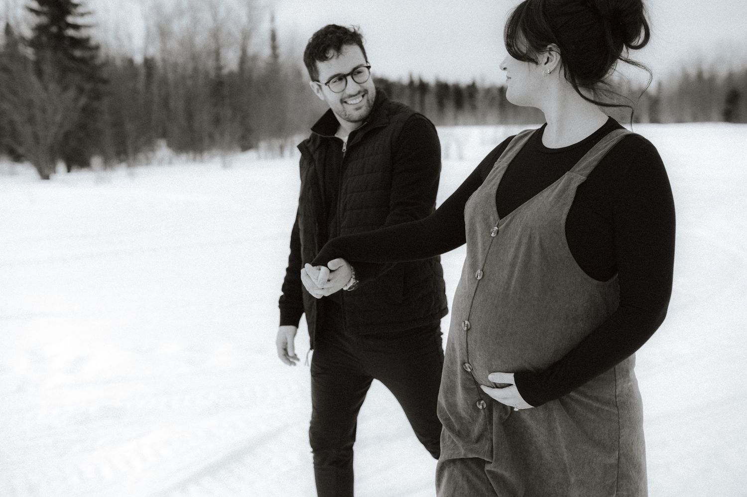 Black and white winter scene showing two people standing in a snowy landscape.