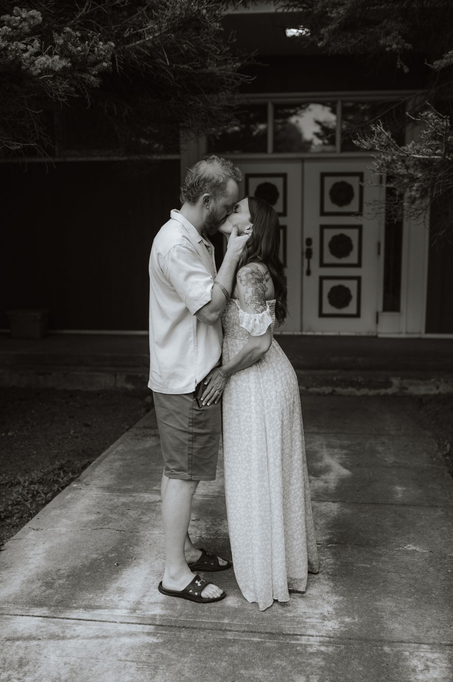 A sequence of black and white photos showing a tender moment between a young child and a person in a white dress on a patio.