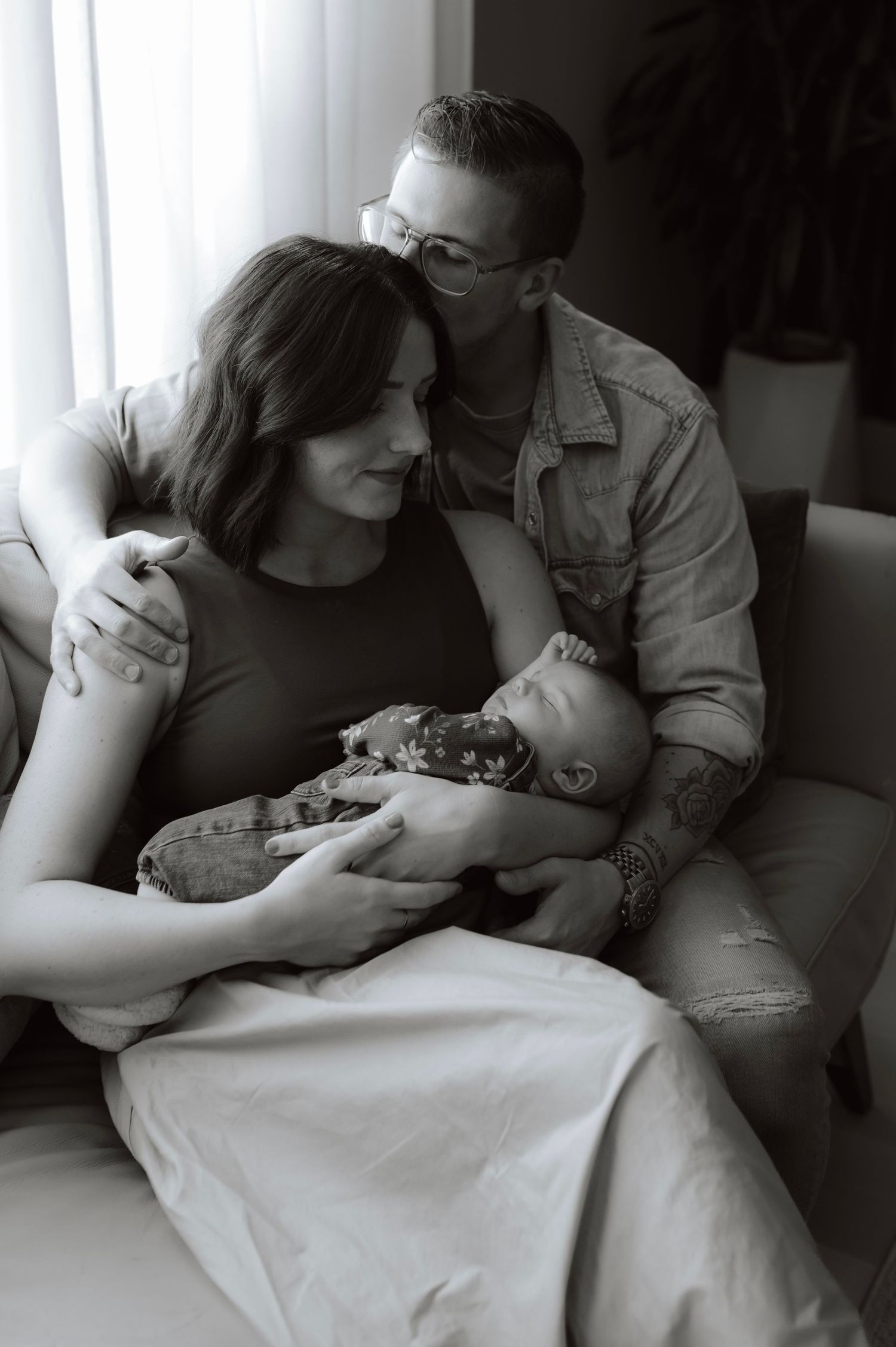 An intimate indoor family moment captured in dramatic black and white lighting.