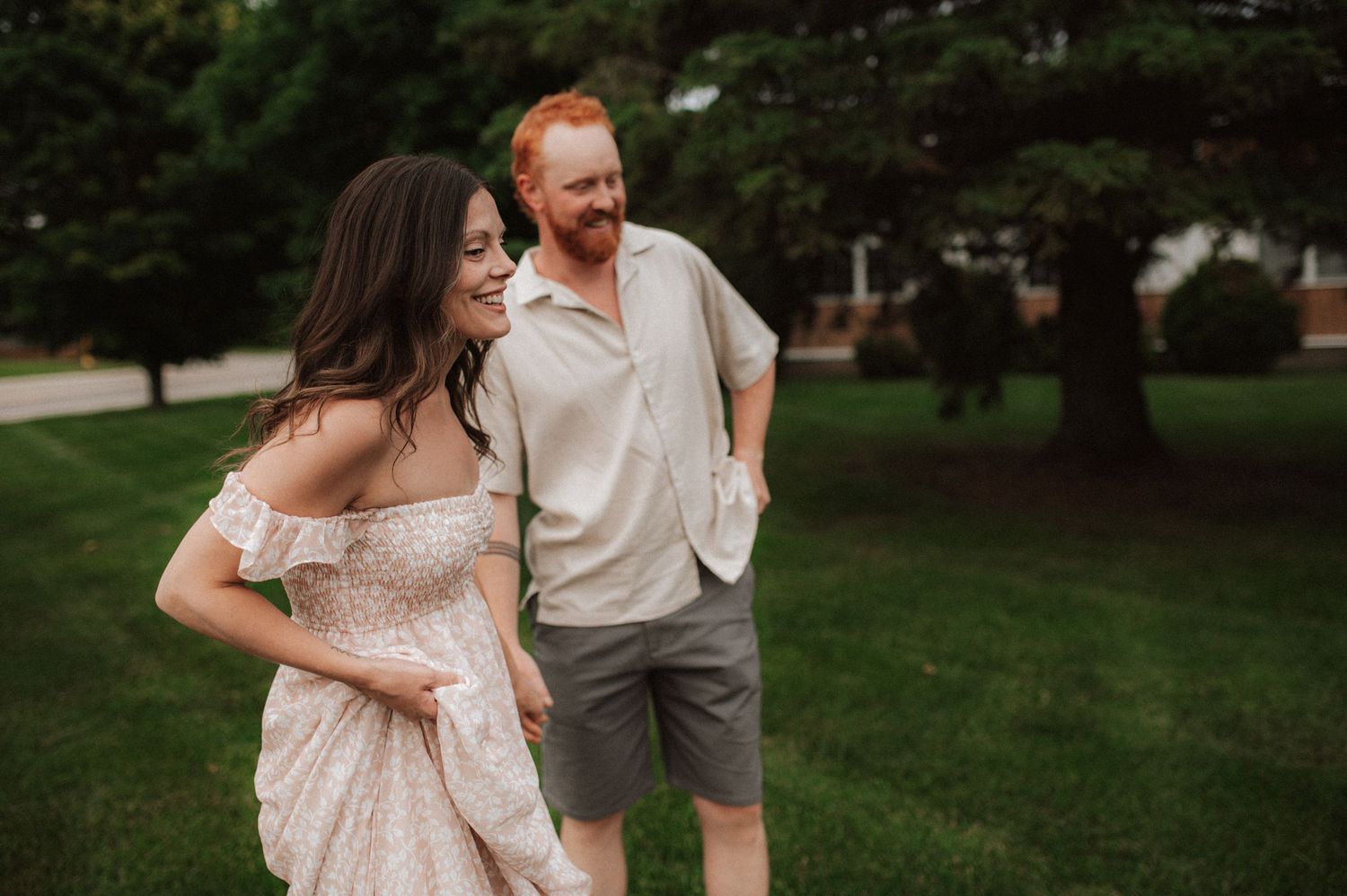 A couple shares happy moments together in a garden setting during a photo session on a sunny day.