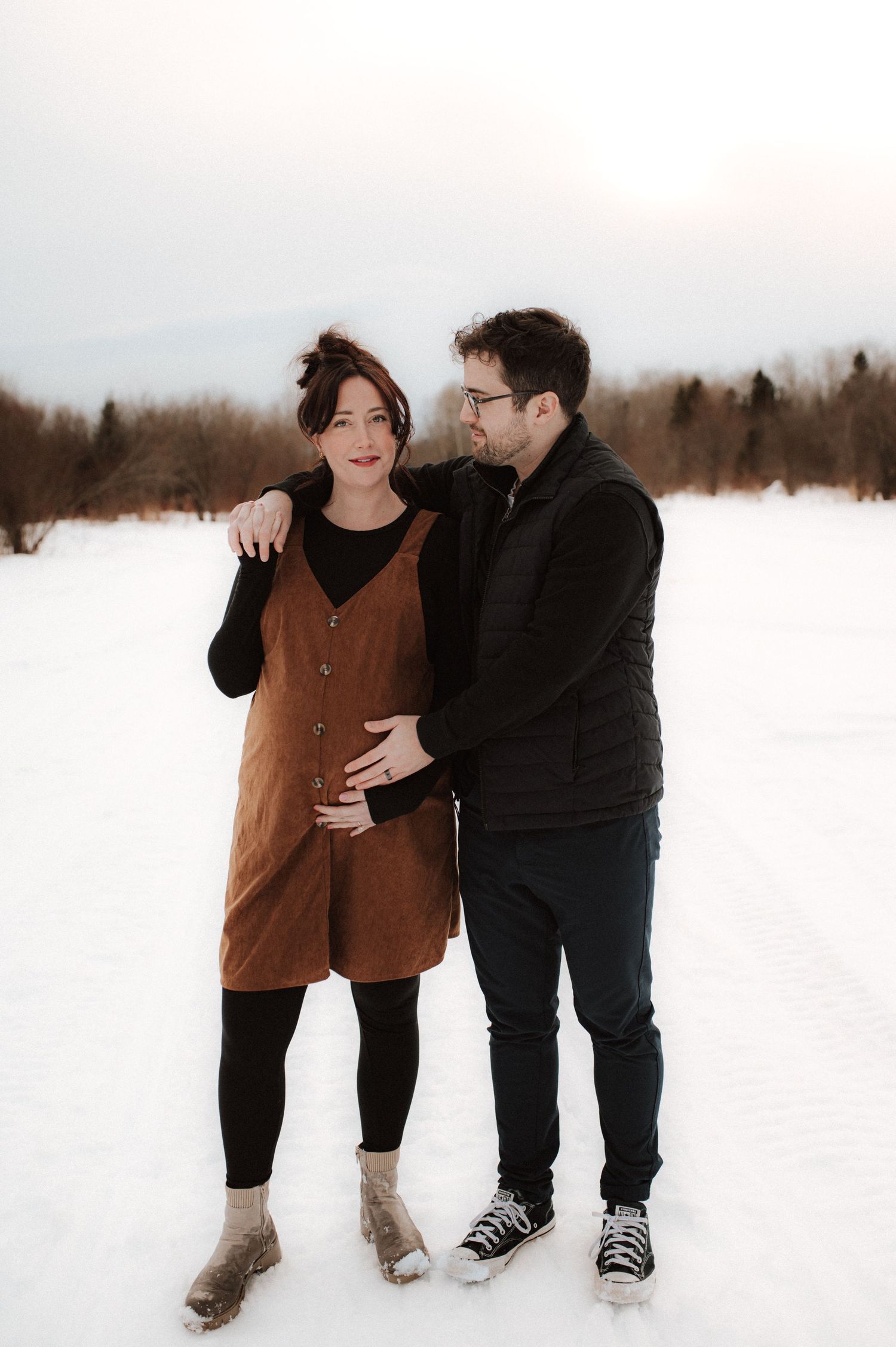 A couple enjoying time together in a snowy winter landscape with playful interactions and matching warm outerwear.