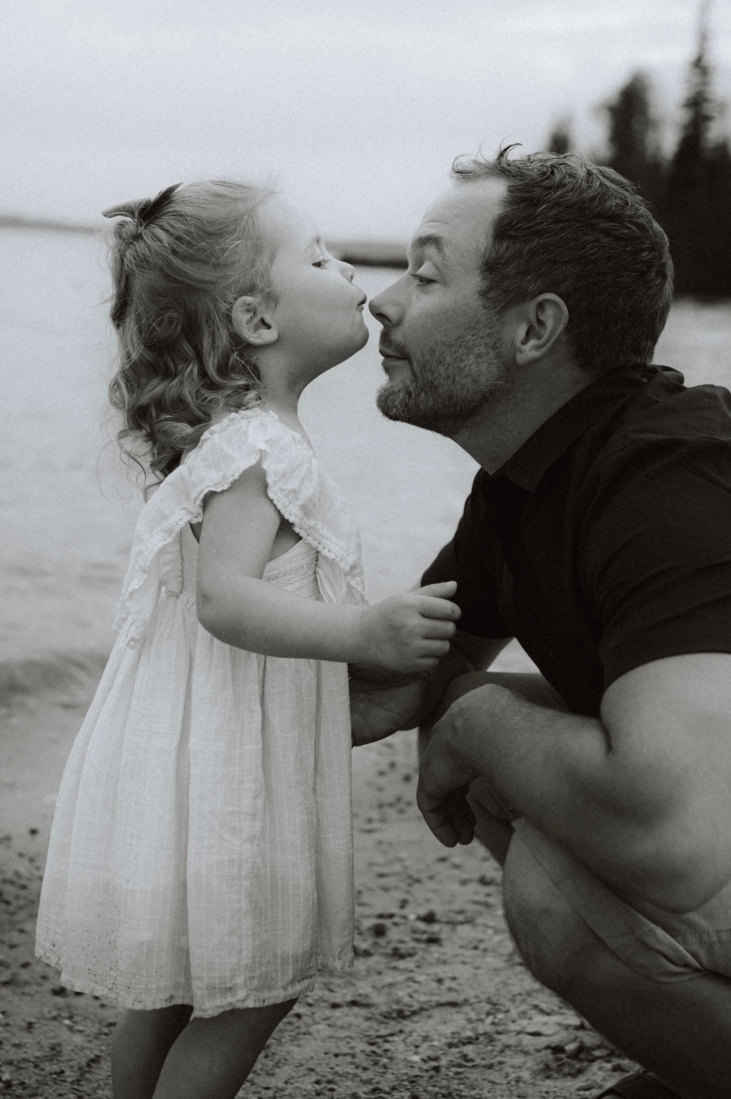 A touching series of black and white photos showing sweet interactions between parent and child on the beach.