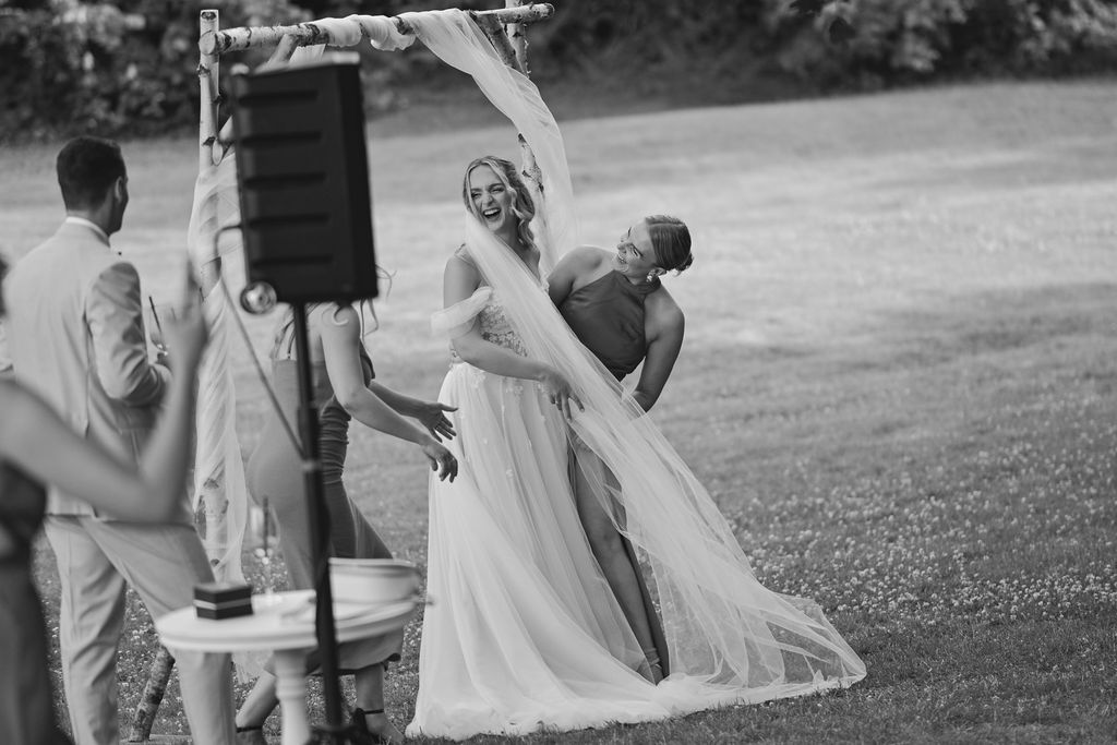 A group of wedding guests walking together on a path through an outdoor garden setting.