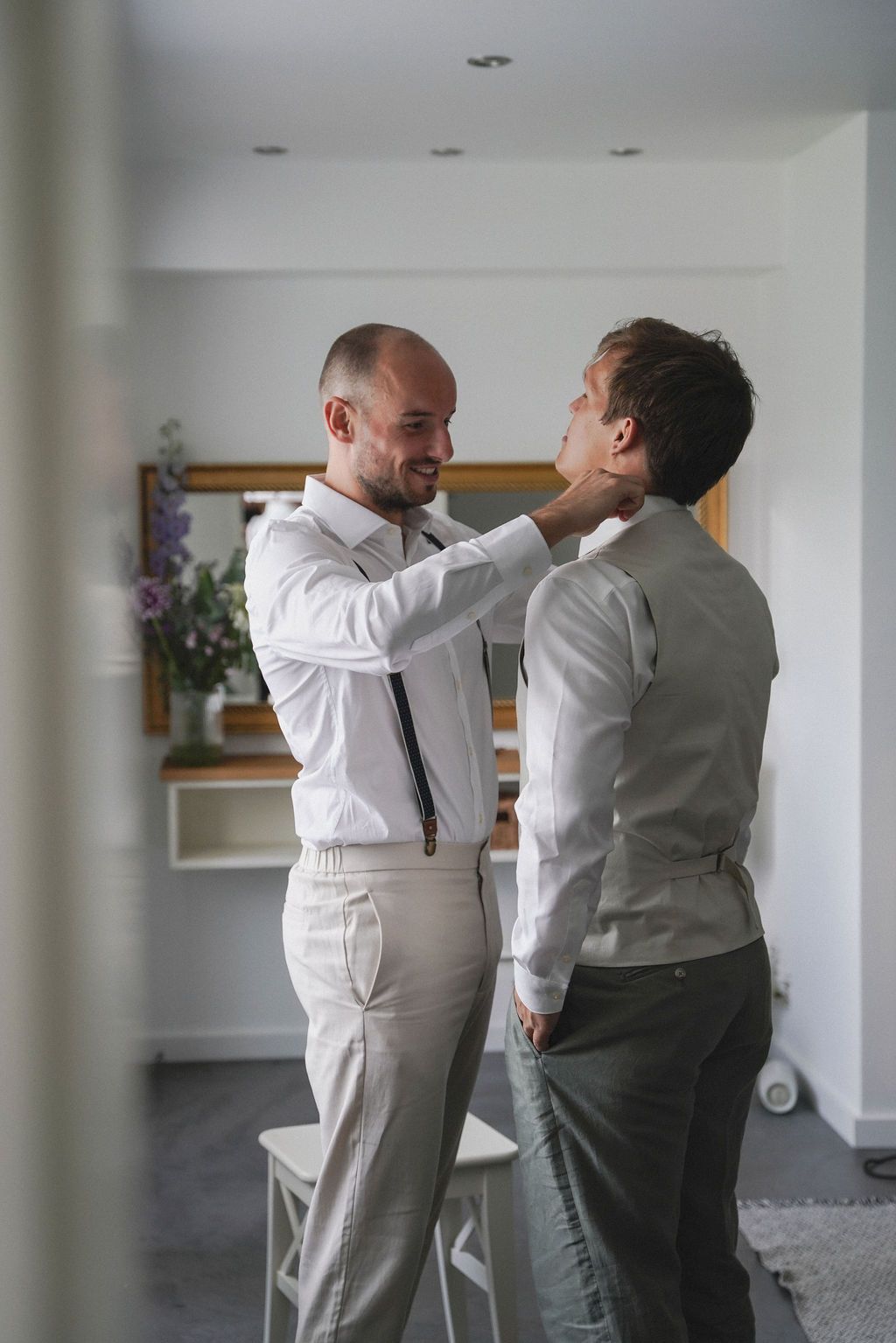 Two people in formal attire sharing an intimate dance moment in a bright indoor space.