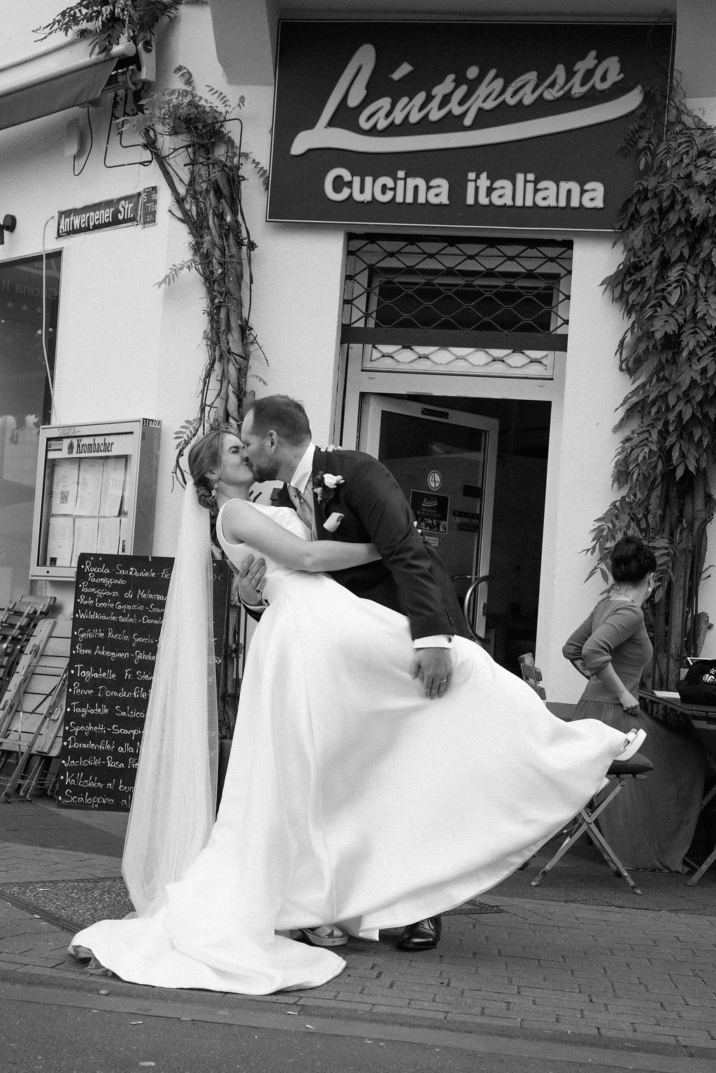 A series of black and white wedding photos showing a couple dancing outside an Italian restaurant called L'antipasto.