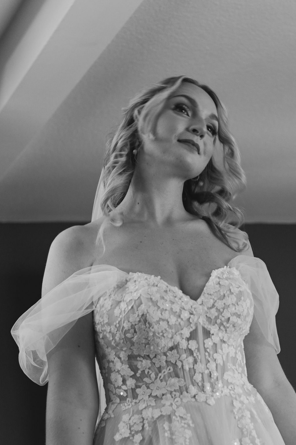 A sequence of black and white photos showing a bride in a delicate floral applique wedding dress with sheer sleeves.