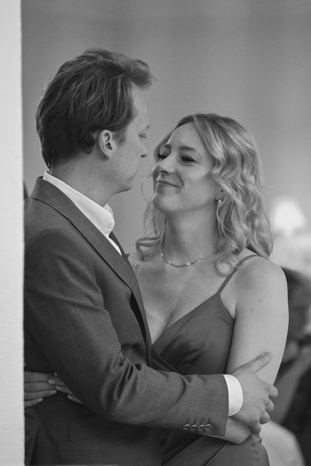 A romantic black and white photo of a couple dancing closely together at a formal event.