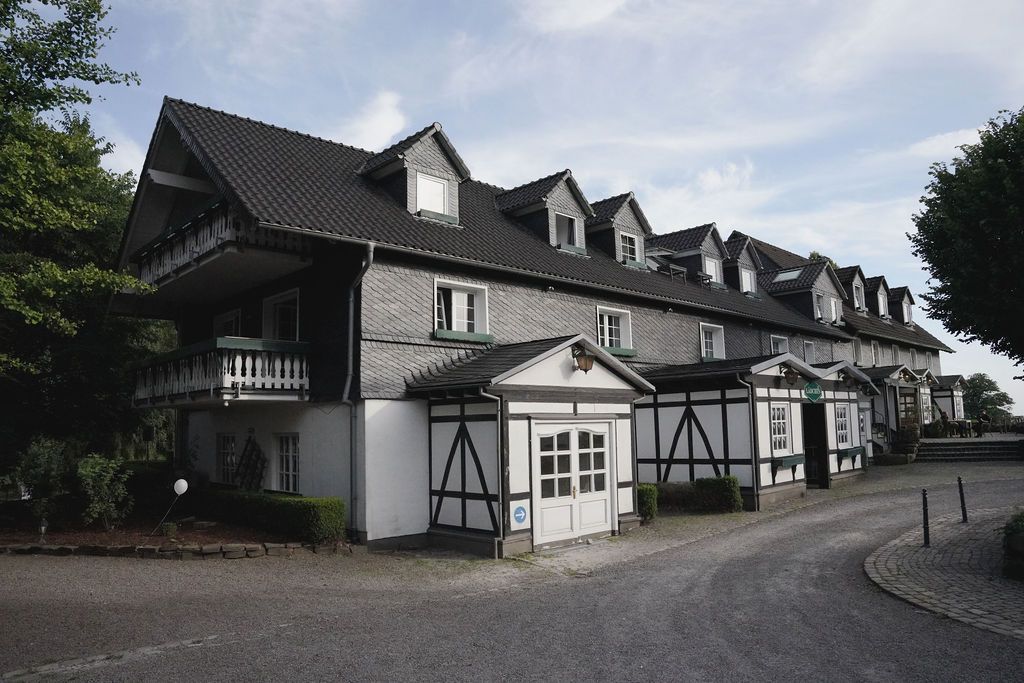 Traditional German-style townhouses with black and white half-timbered facades and dormer windows line a quiet residential street.