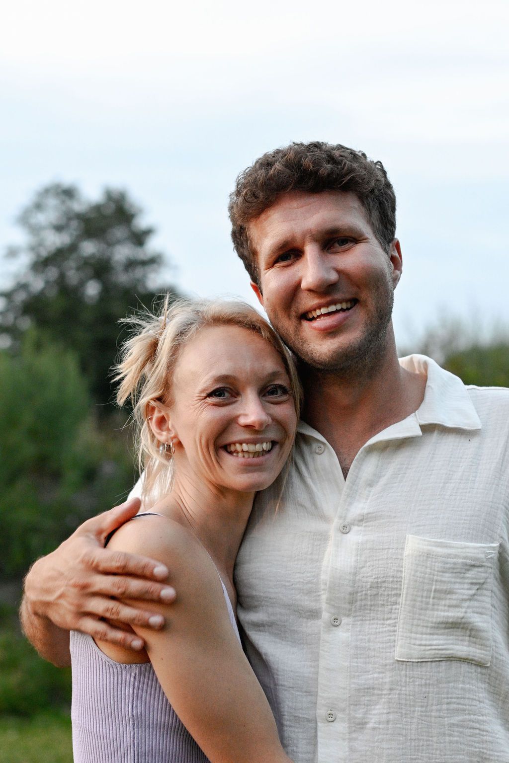 A progression of joyful outdoor portraits showing a couple sharing loving embraces and genuine laughter.