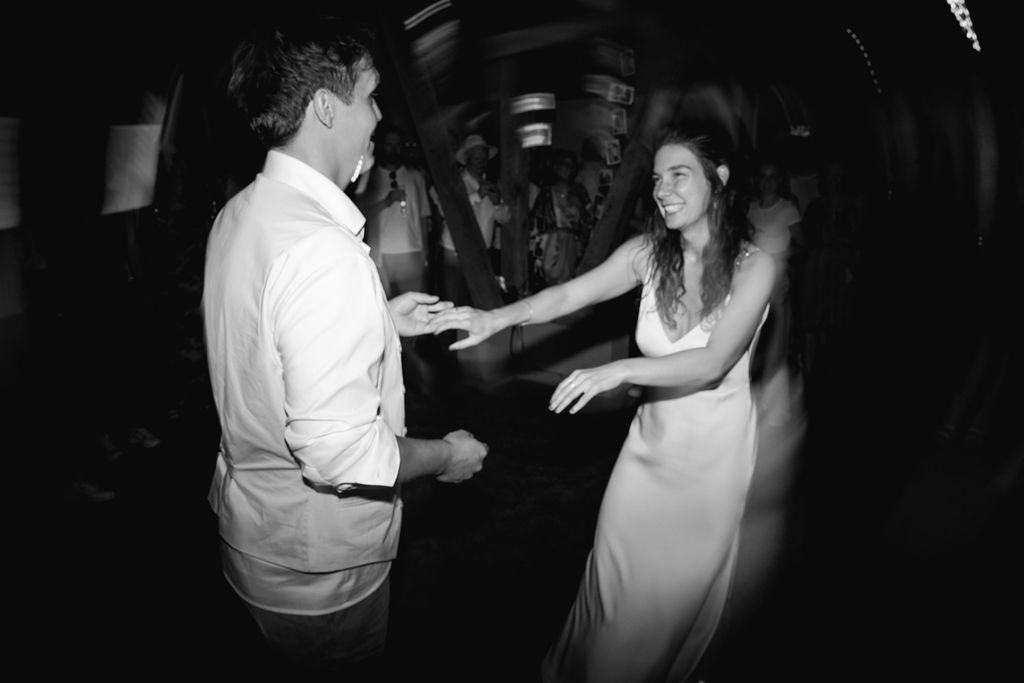 A group of people dancing together at a dimly lit party or celebration venue.