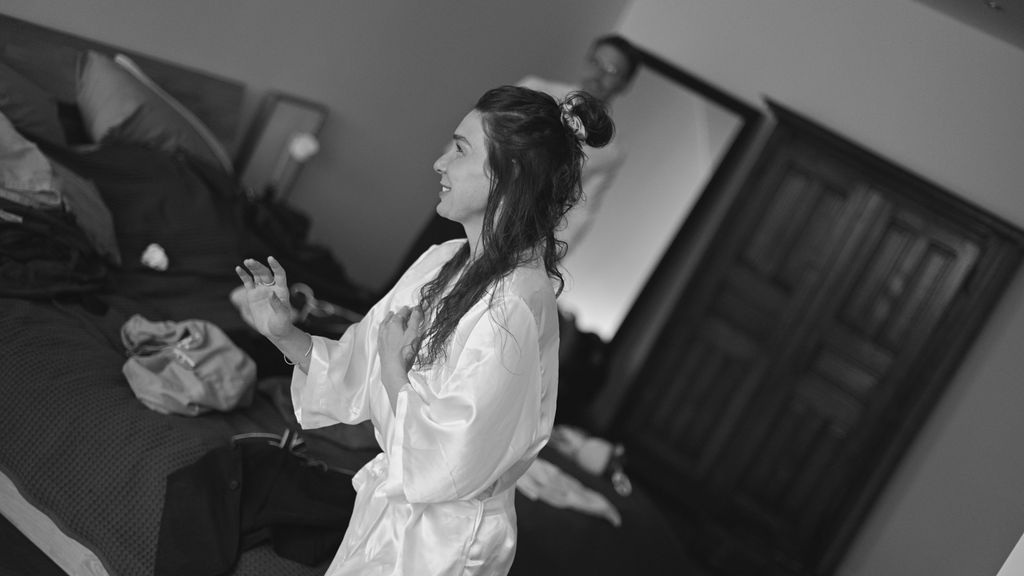 A person in white martial arts attire practicing moves in a training studio.