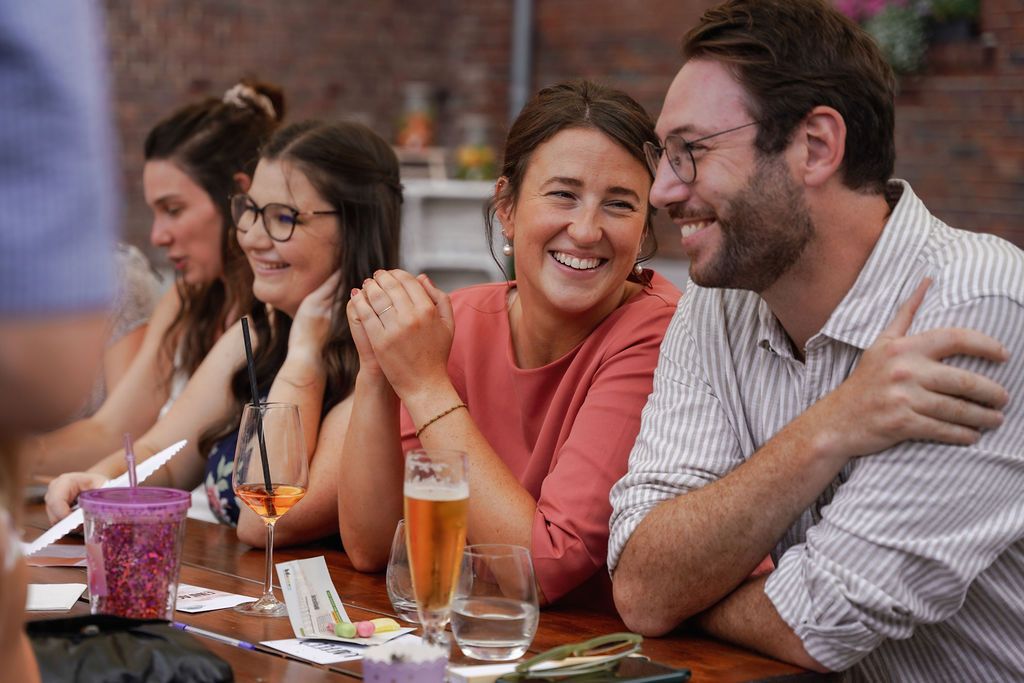 Friends enjoying drinks and conversation while socializing at an outdoor restaurant patio.