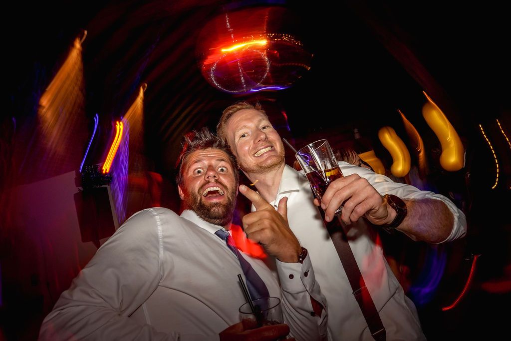 People enjoying themselves at a nightclub with colorful lighting and energetic atmosphere.