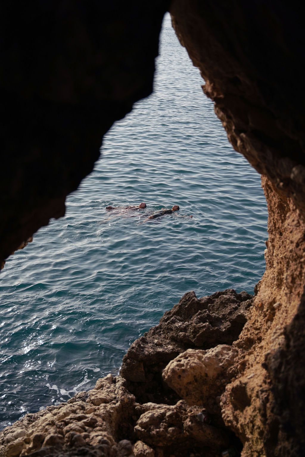View from inside a coastal cave looking out at the blue Mediterranean waters.