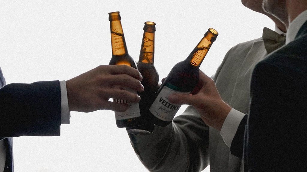Beer bottles being held up in a toast between business colleagues.