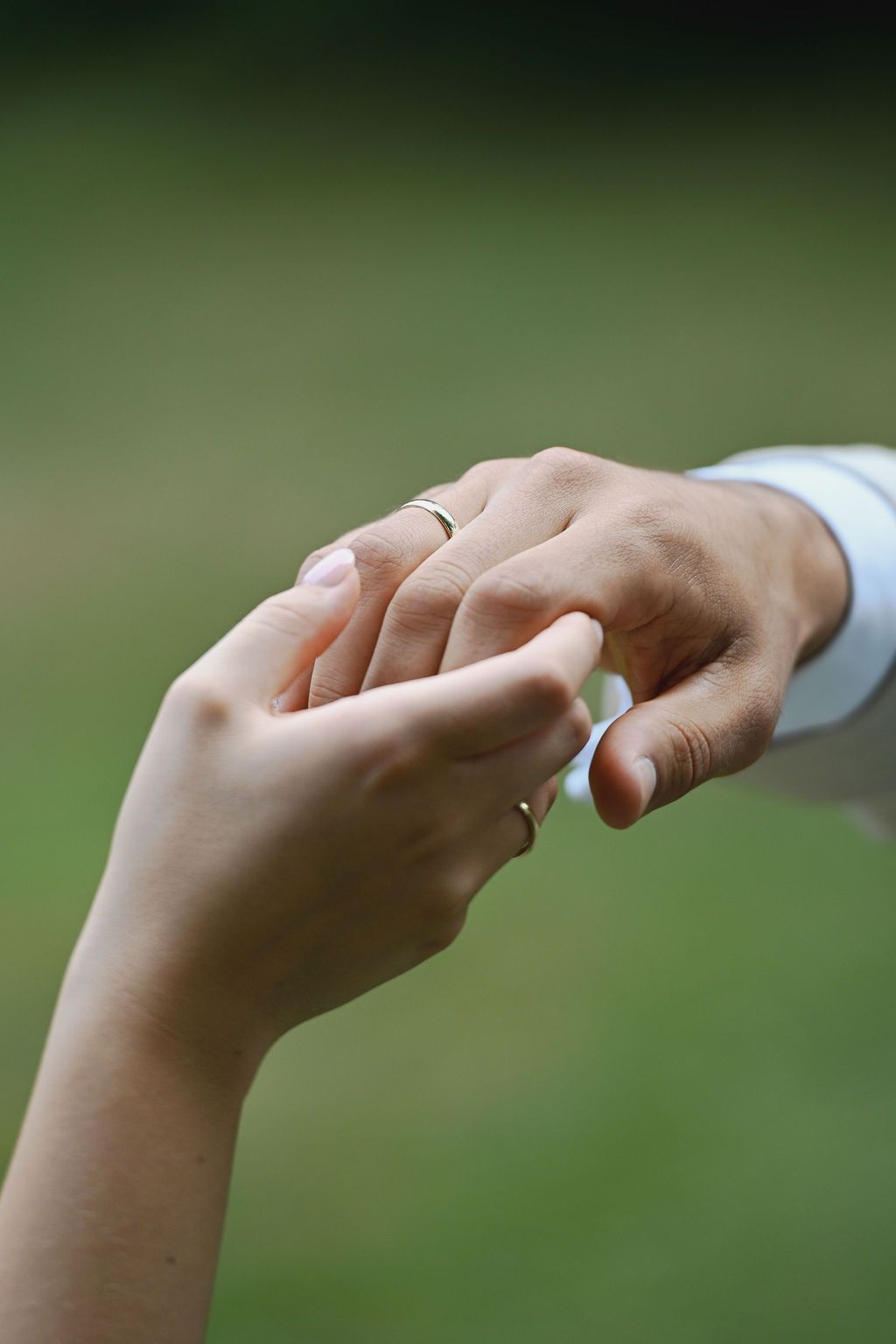A sequence of hands showing different angles and positions of a ring against a blurred green background.