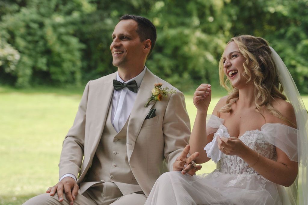 A couple shares a joyful moment during their outdoor wedding ceremony.
