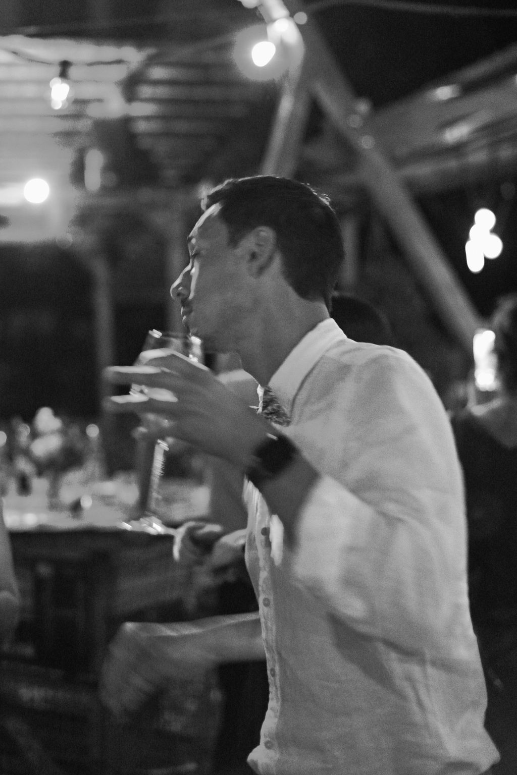 A sequence of black and white photos showing someone in white clothing moving dynamically in a dimly lit space.