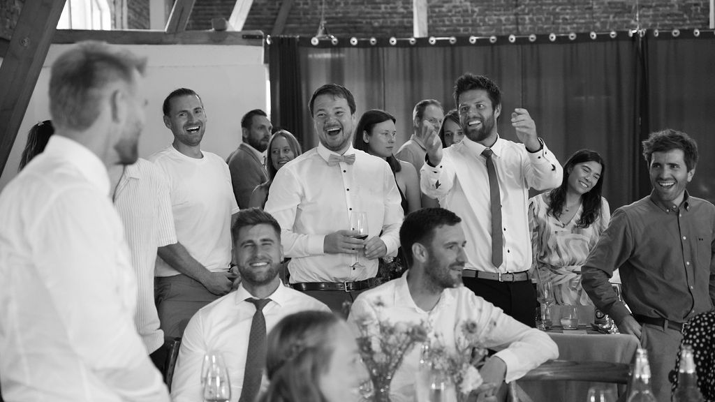 A black and white panoramic collage of people gathered in what appears to be a restaurant or dining establishment.