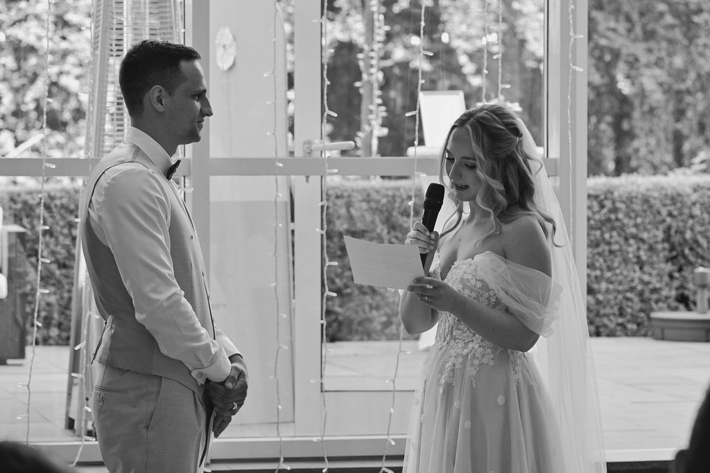 A series of romantic black and white wedding photos showing couples sharing intimate moments by glass doors.
