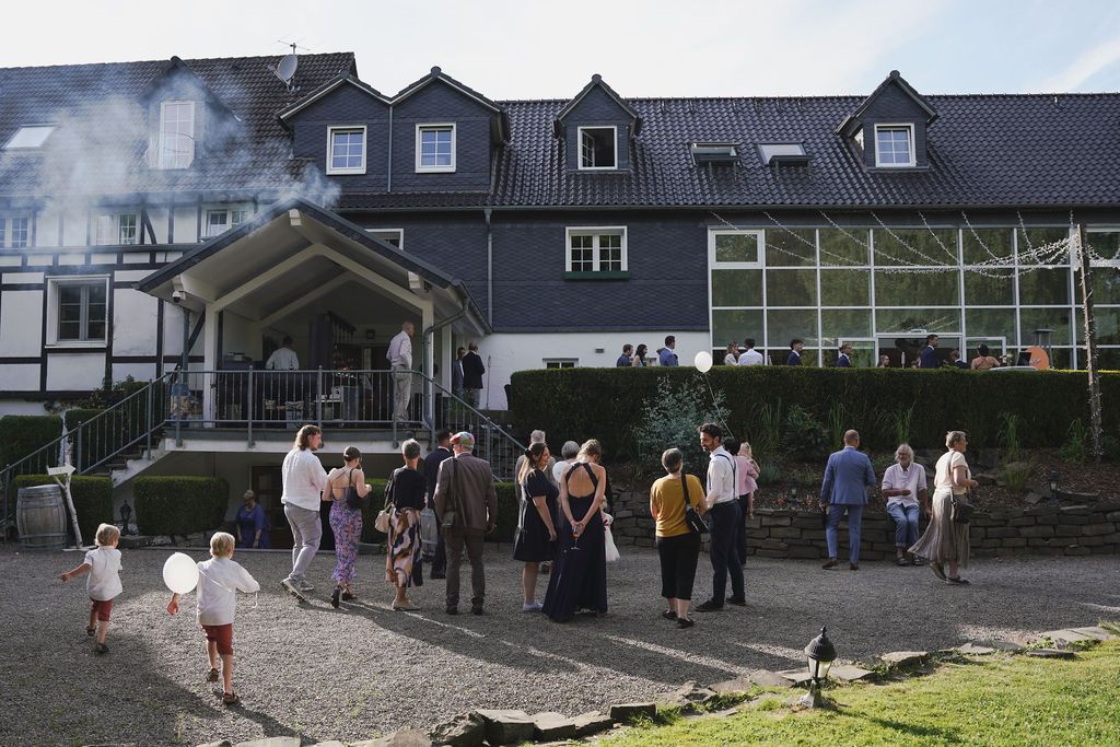Students gather outside a school building during a social event on a sunny day.