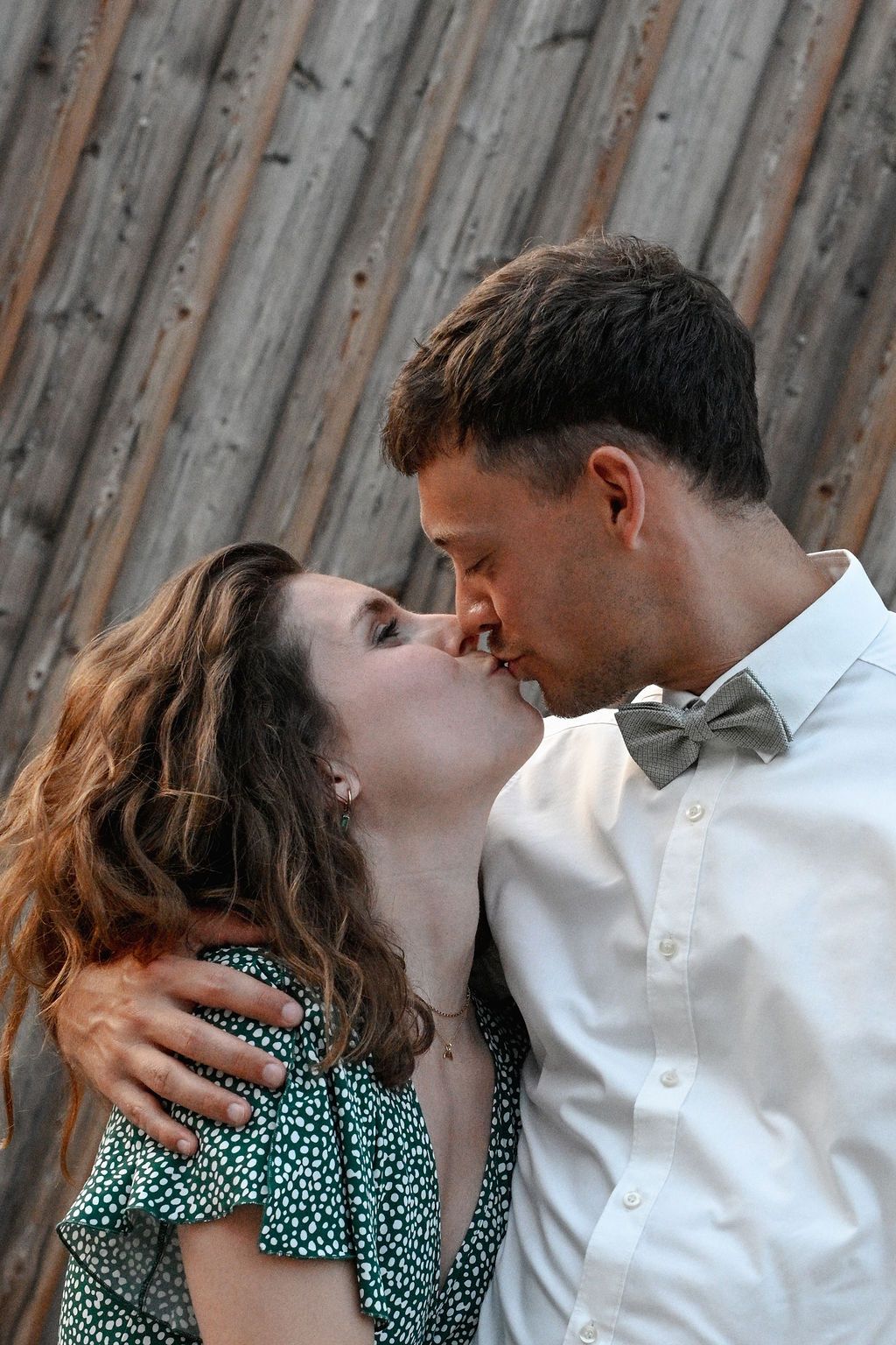A romantic sequence of a couple embracing and sharing intimate moments against a rustic wooden fence background.
