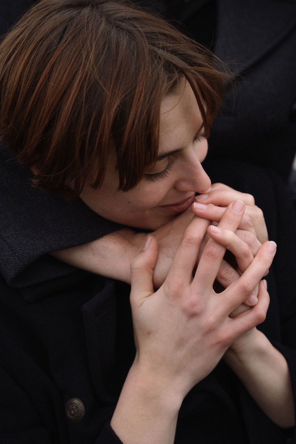 A person covers their face with both hands against a dark background in a series of dramatic emotional poses.