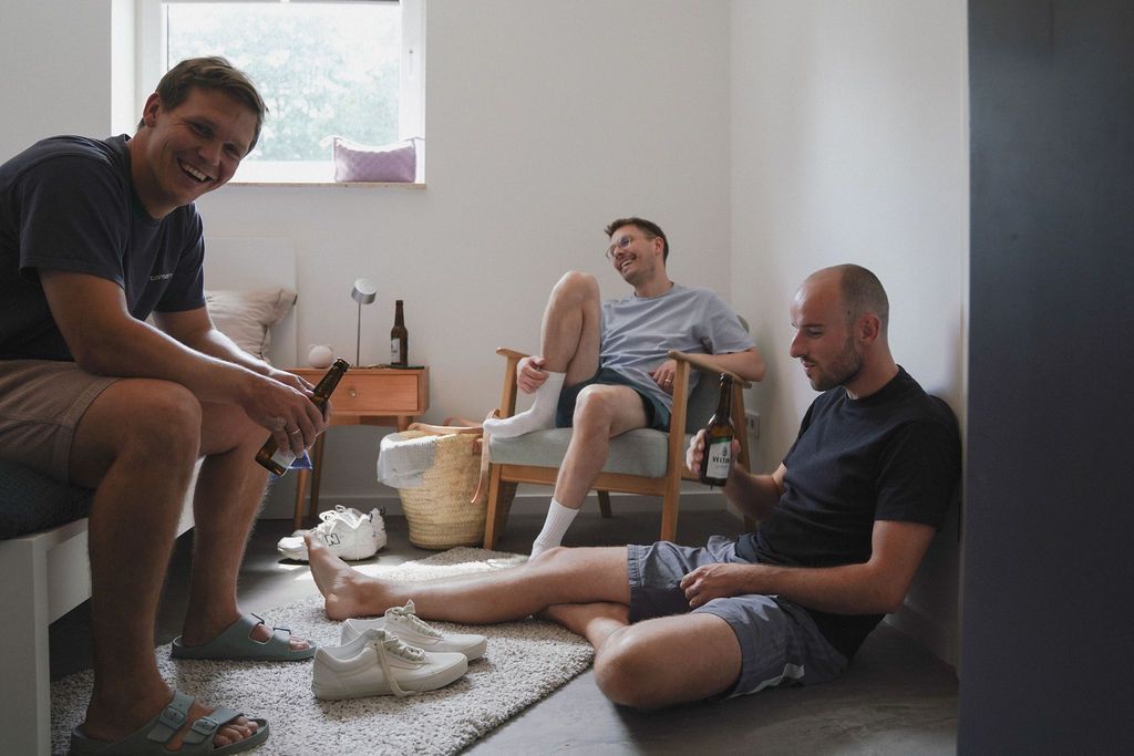 People gathered around a table working together with flour and dough to make homemade pasta.