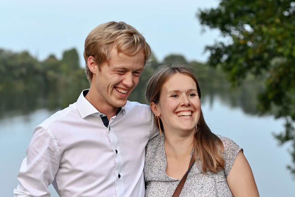A series of candid romantic moments between a couple laughing and embracing outdoors near a lake.