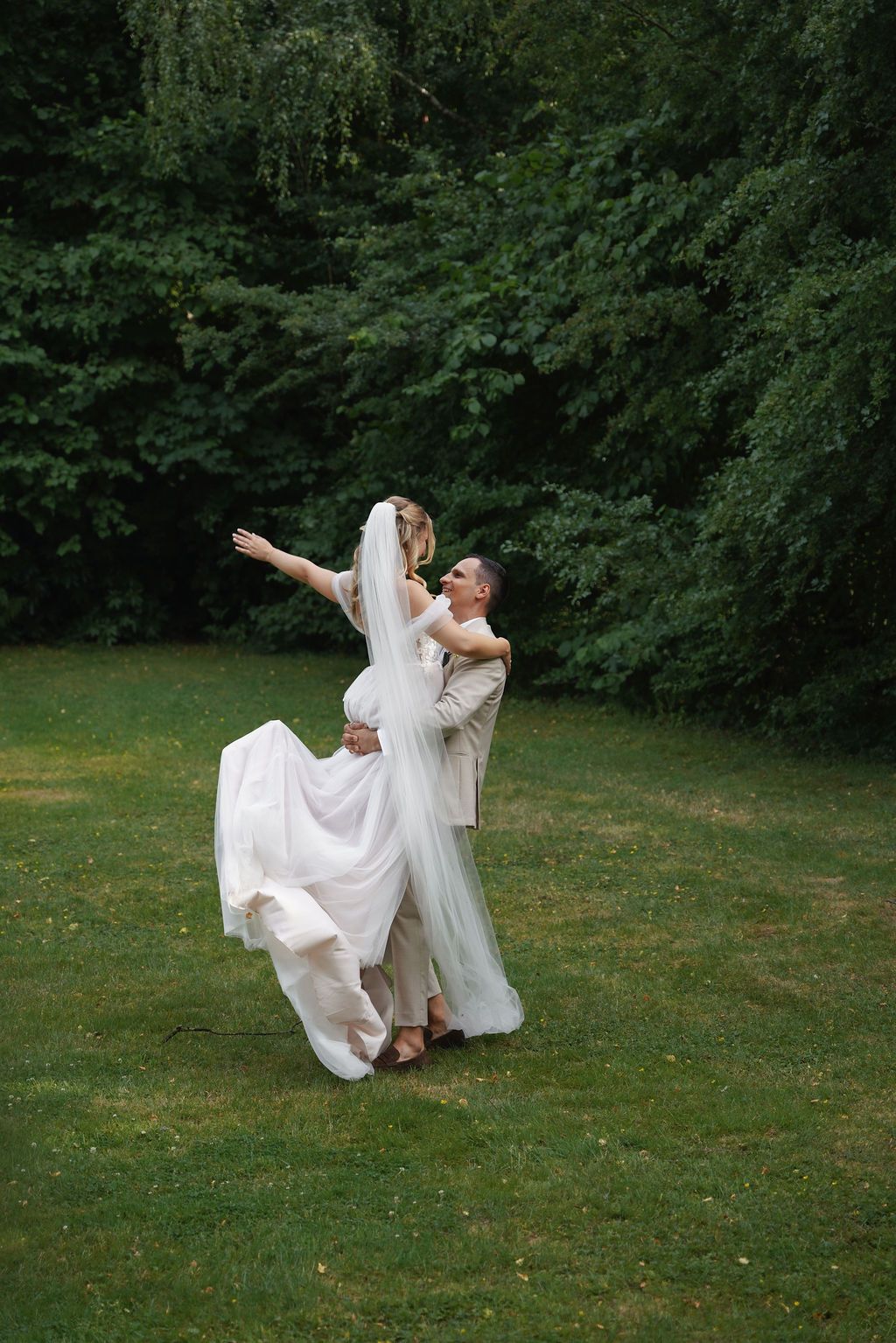 A sequence of photos showing a bride in a flowing white dress dancing and twirling on a green lawn surrounded by trees.