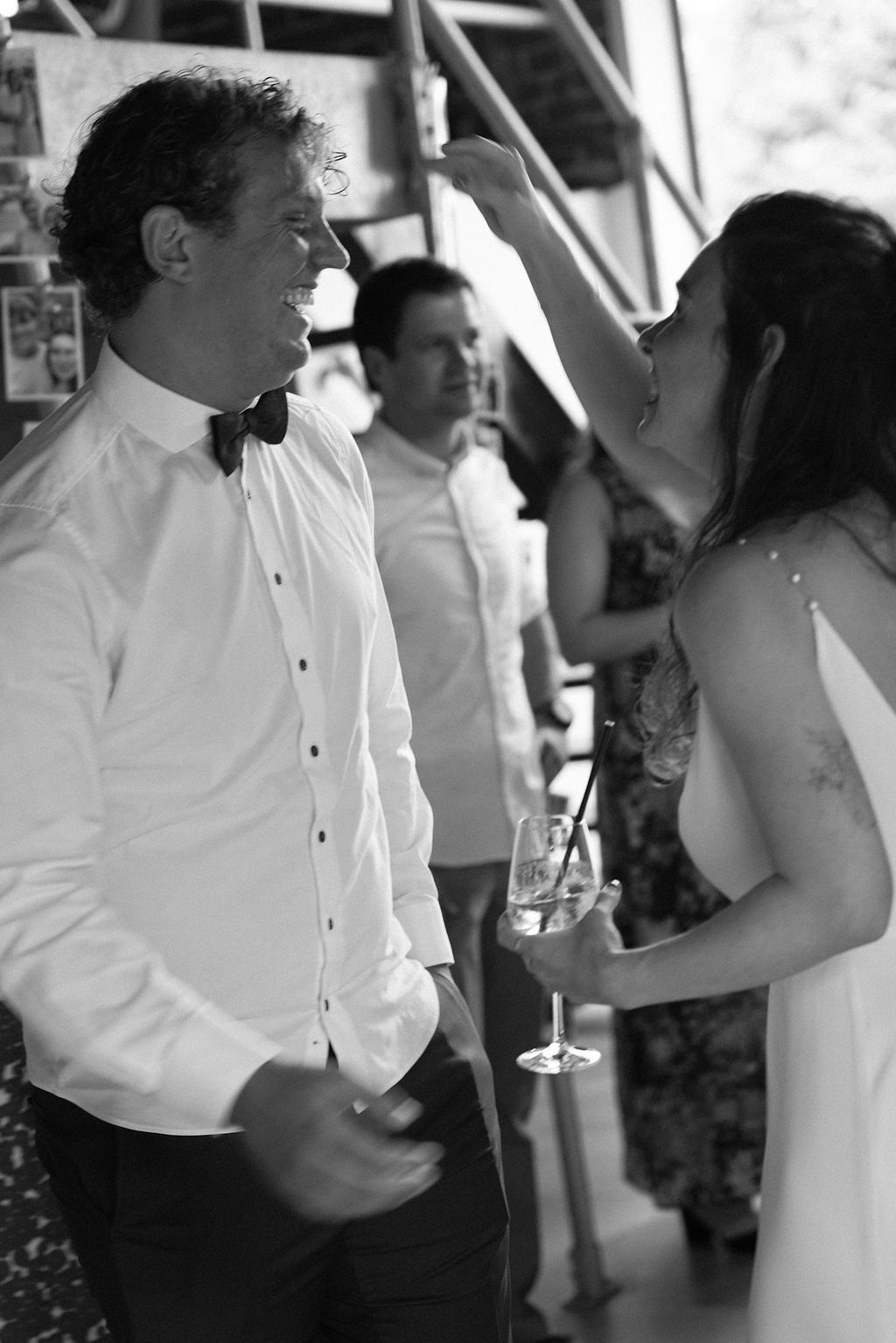 Black and white candid photo of guests chatting and socializing at an elegant party or reception.