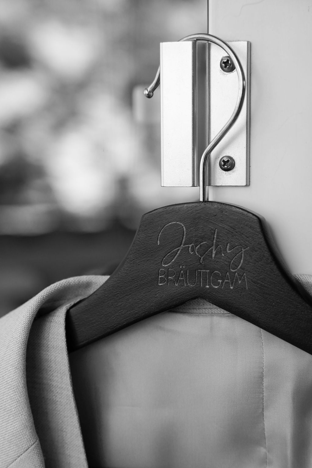 Black wooden hangers with engraved text line up against a white wall.
