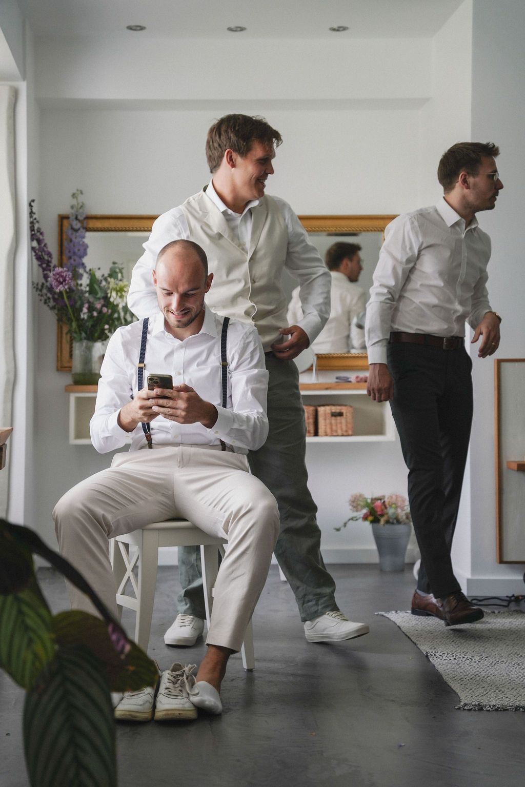 A sequence of images showing a person in white clothing performing a tying shoelace motion in a modern interior space.