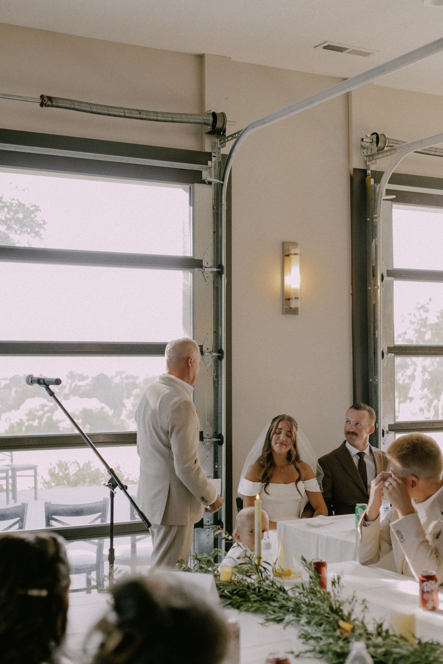 Wedding reception venue with large windows and natural lighting.