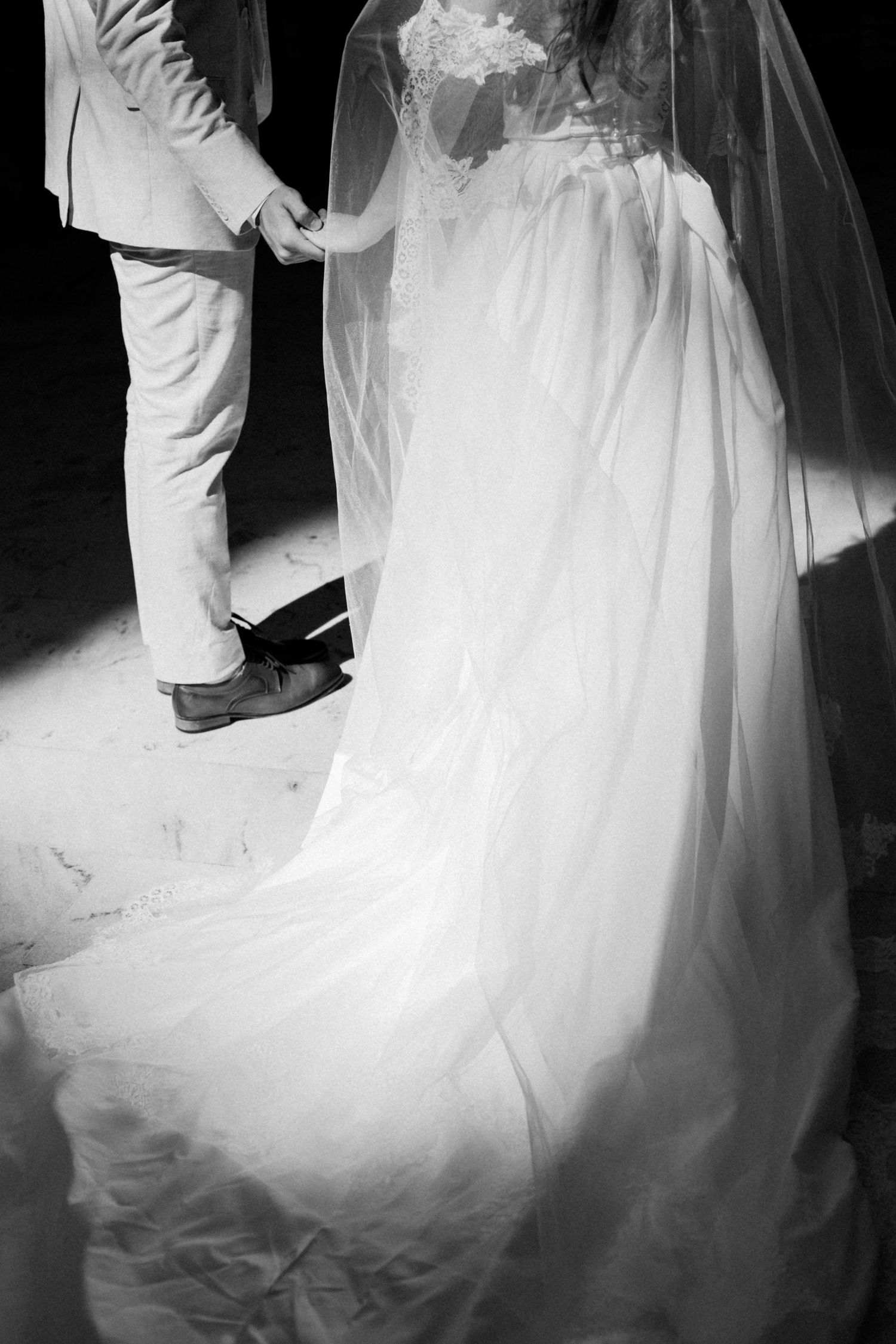 Dramatic black and white wedding photos showcase flowing white dress and romantic poses.