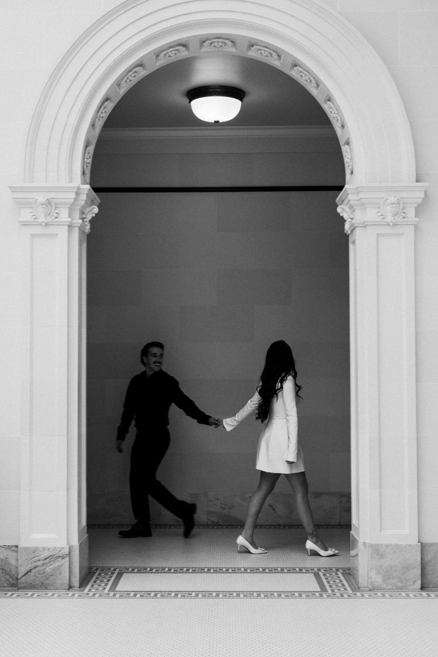 Black and white series showing playful interactions through architectural archways.