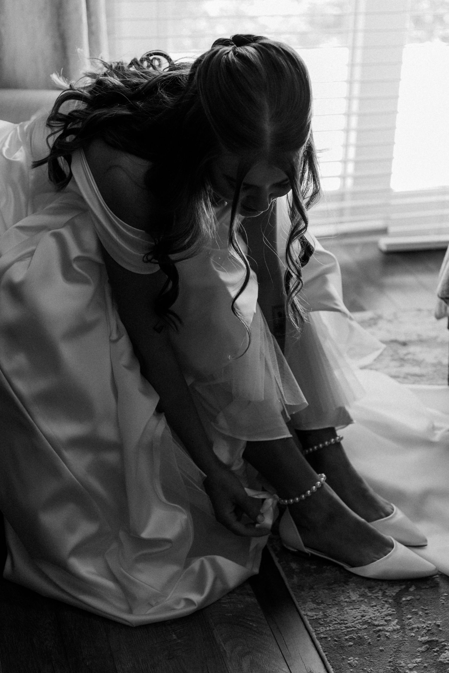 Black and white photo showing wedding dress details and preparations.