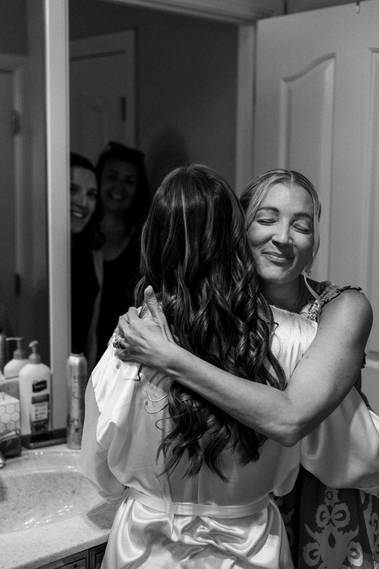 Black and white photo showing joyful moments during wedding preparations.