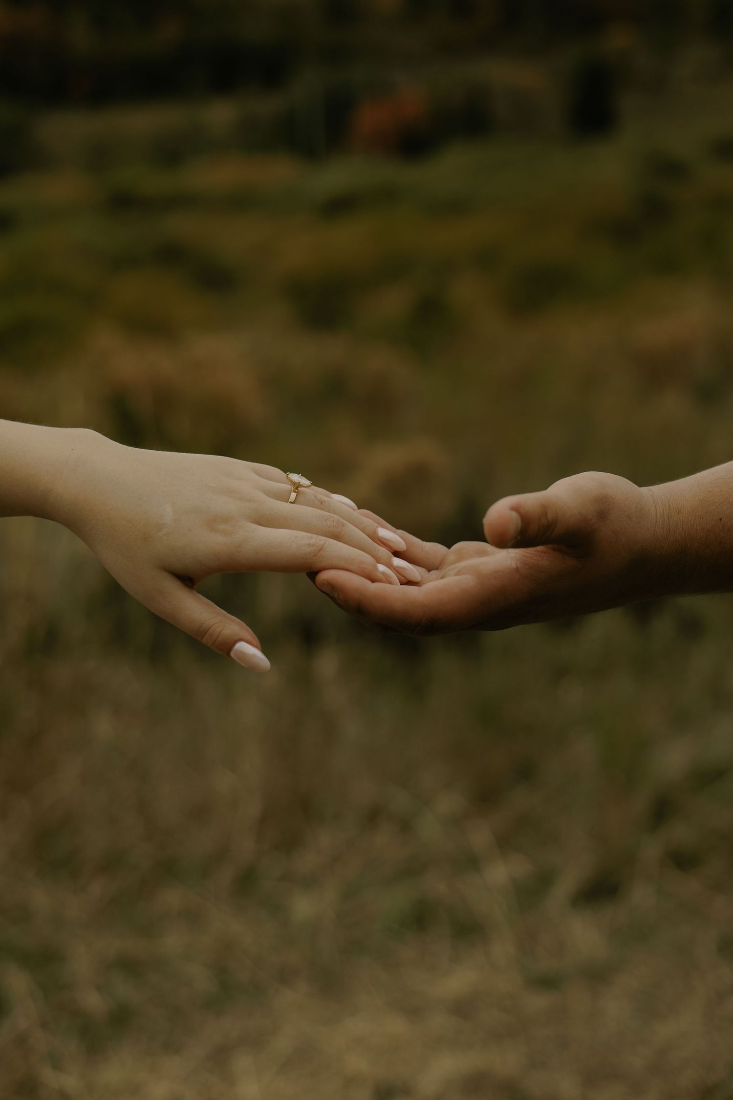 Close-up shots of hands reaching towards each other against a dark background.