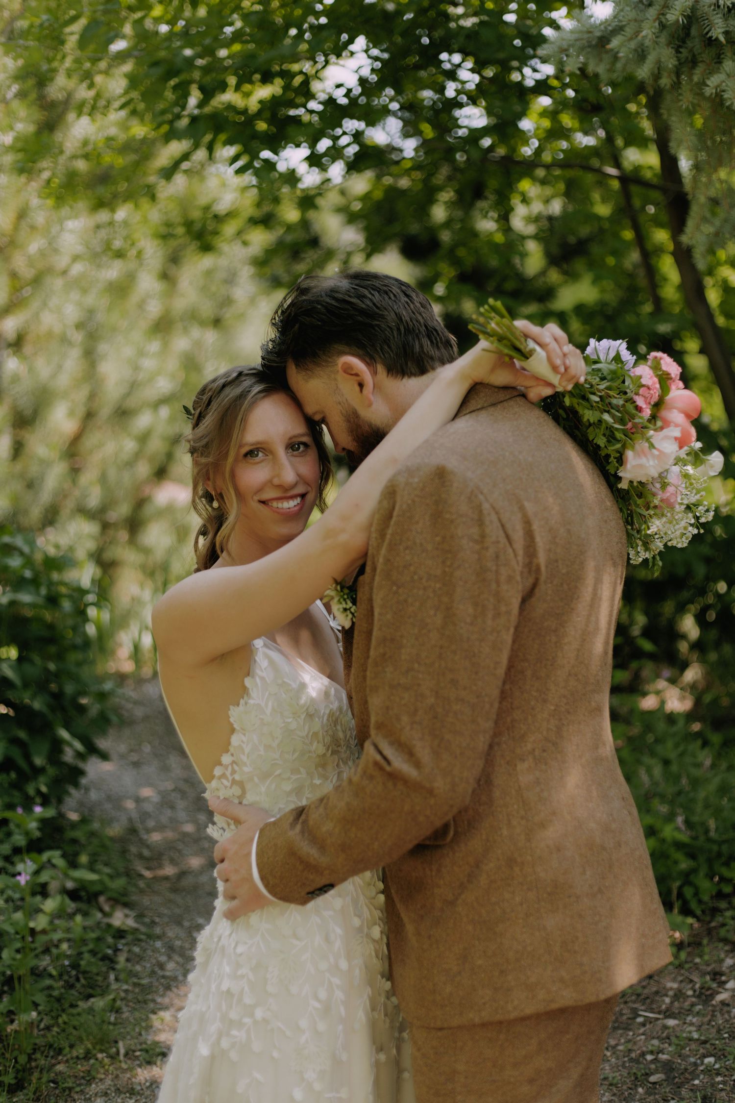 Wedding couple sharing a playful moment in a garden setting.
