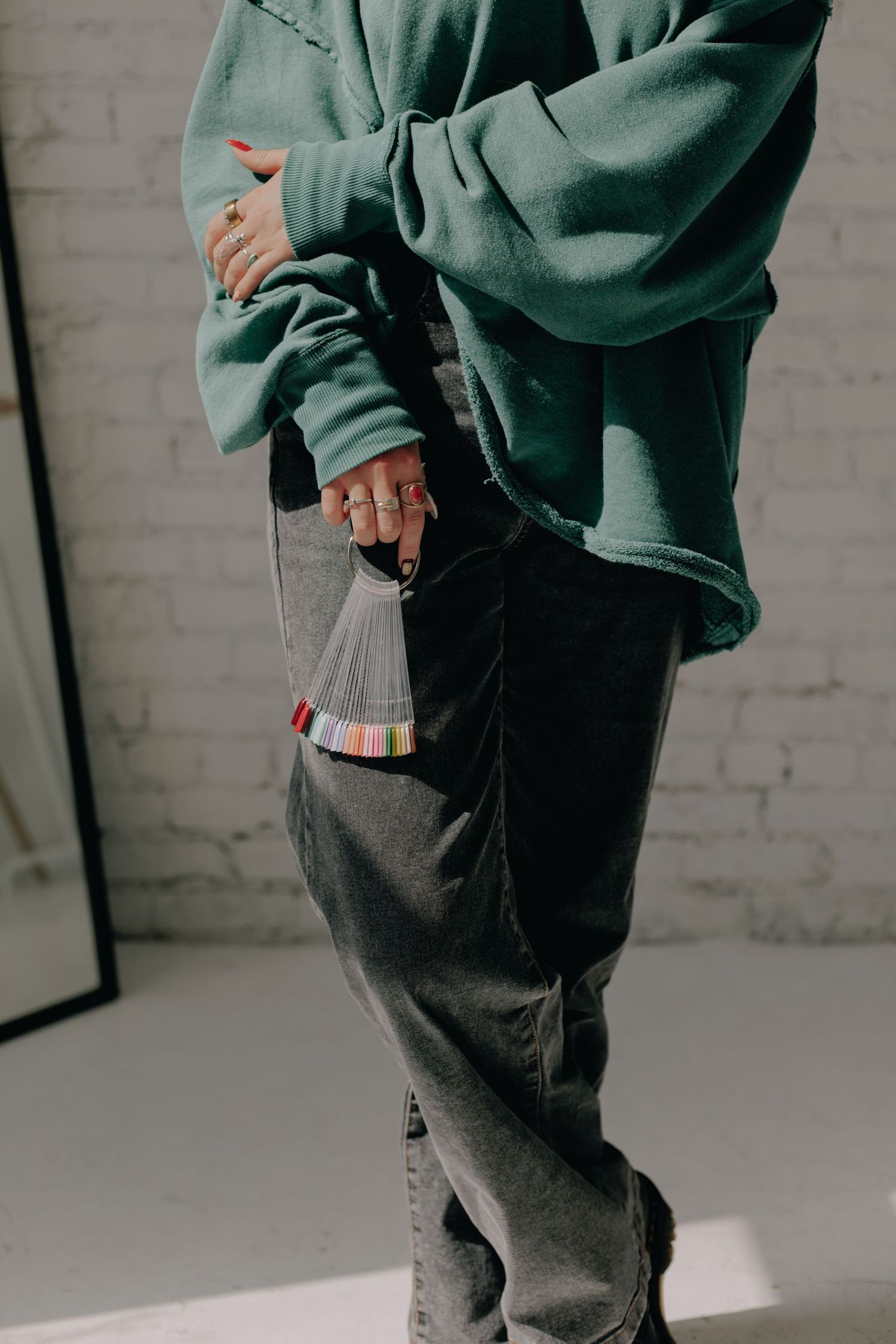Side view of person wearing oversized green sweatshirt and dark pants in casual pose.