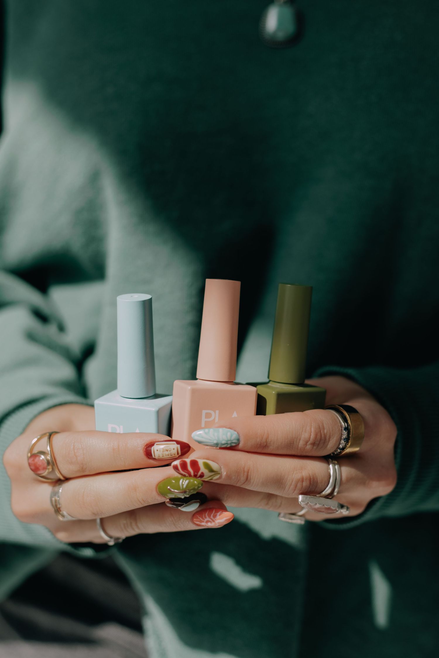 Close-up shots of hands with painted nails holding various nail polish bottles.
