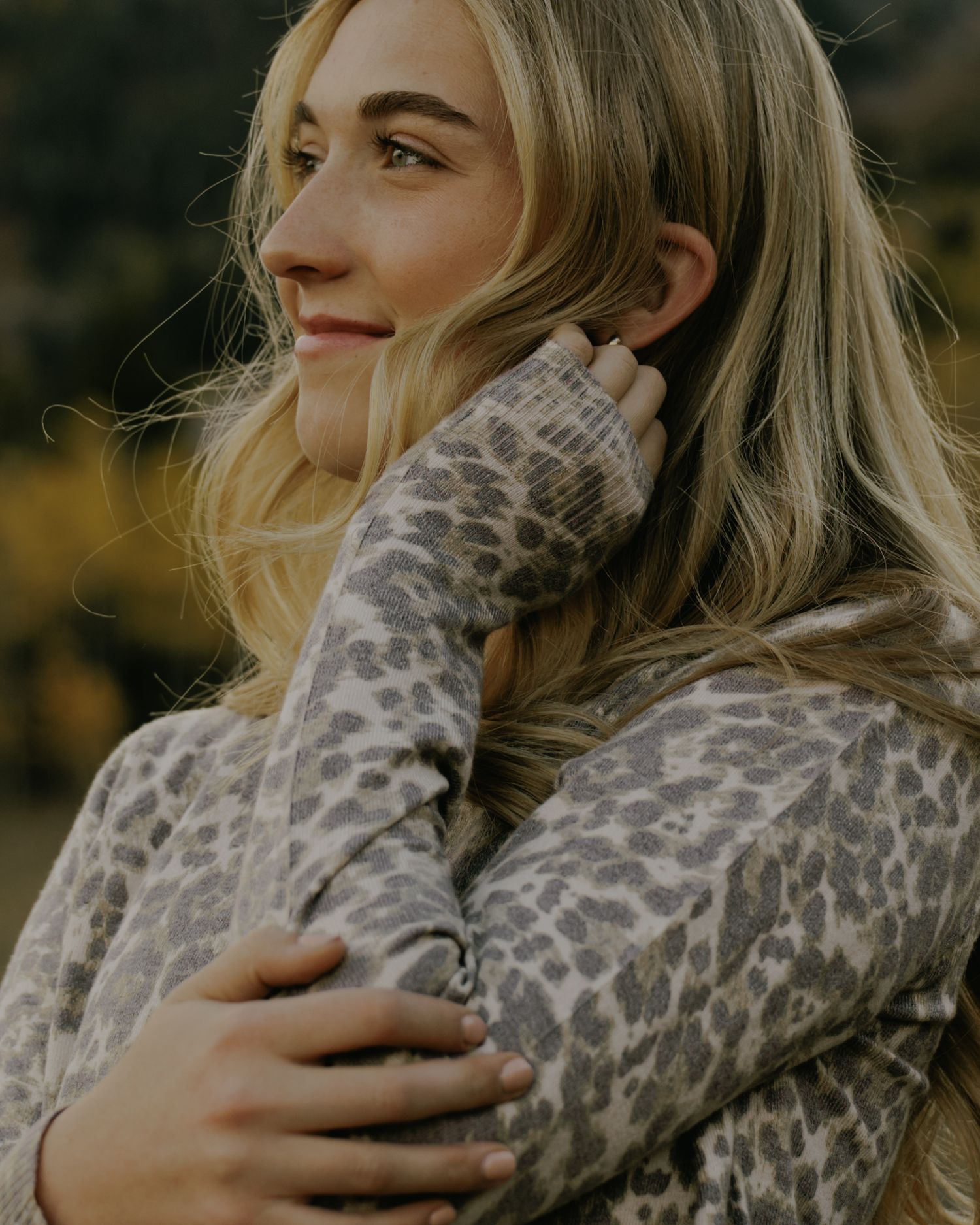 Close-up of person wearing animal print sweater in golden autumn light.