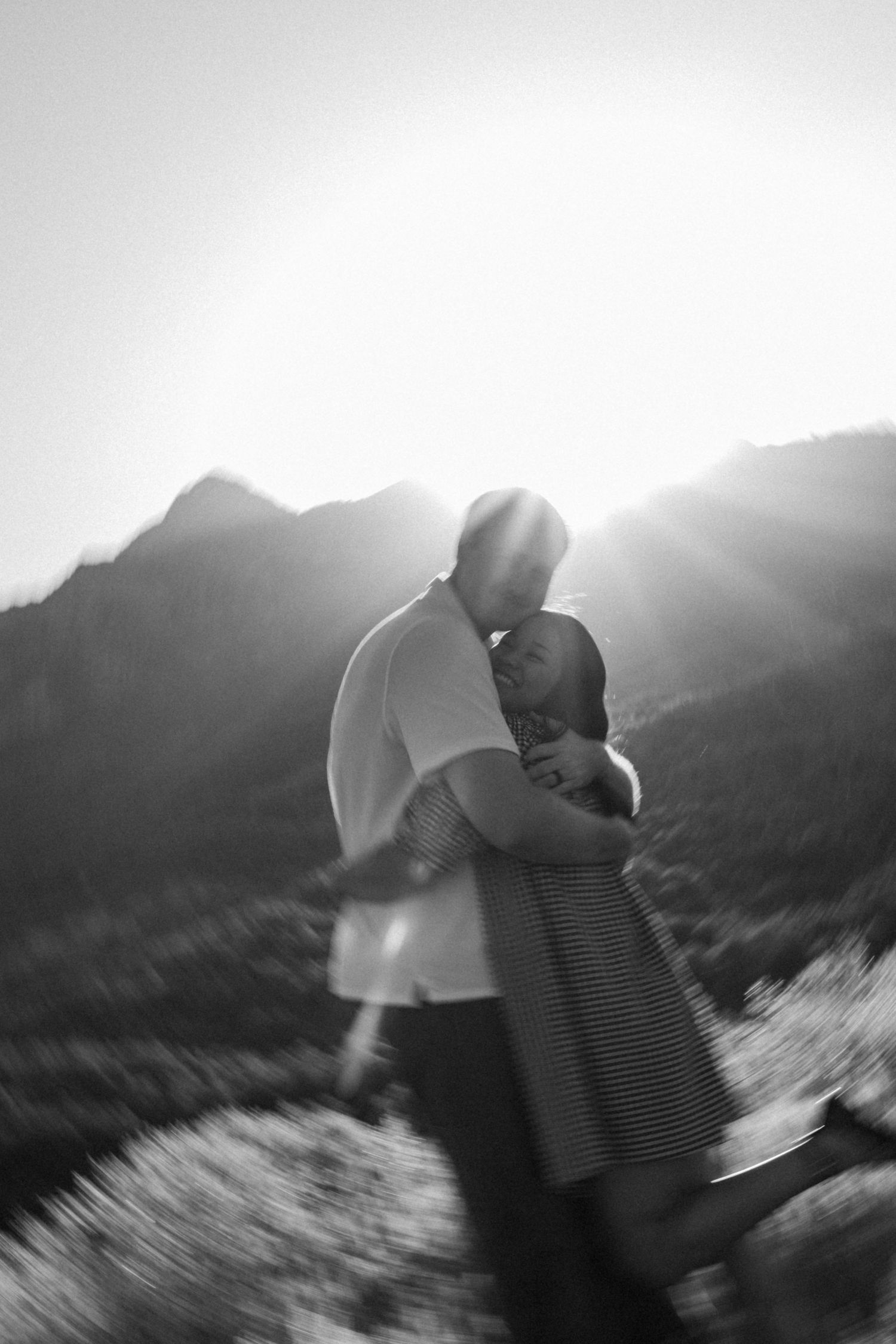 A dreamy black and white sequence showing movement and romance against mountain silhouettes.